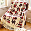 Woven cotton blanket with books, mugs and pencils motif draped on a reading chair